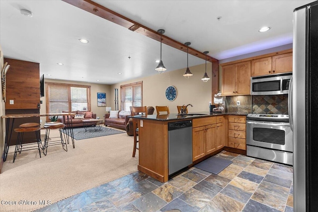 834 Mckinley Ave Unit 208, Kellogg, ID 83837 - kitchen with appliances with stainless steel finishes, dark countertops, a peninsula, dark colored carpet, and a sink