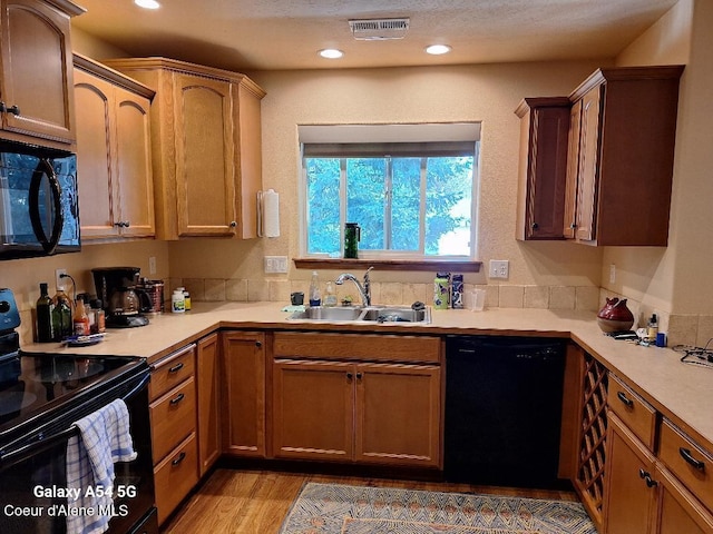 368 E Whispering Pines Ln # 6, Coeur Dalene, ID 83815 - kitchen featuring visible vents, a sink, light countertops, black appliances, and light wood finished floors