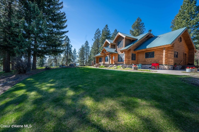 view of front of home featuring log siding, a standing seam roof, metal roof, and a front lawn