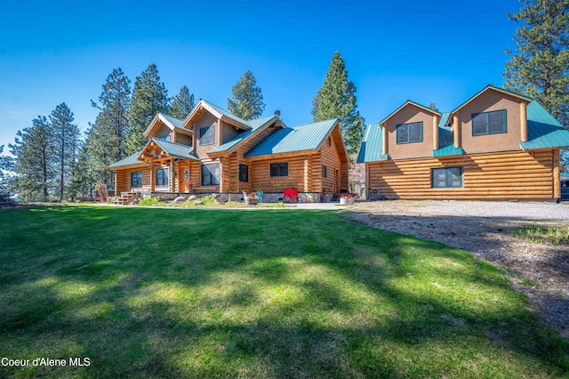 cabin featuring metal roof, a front lawn, and log exterior