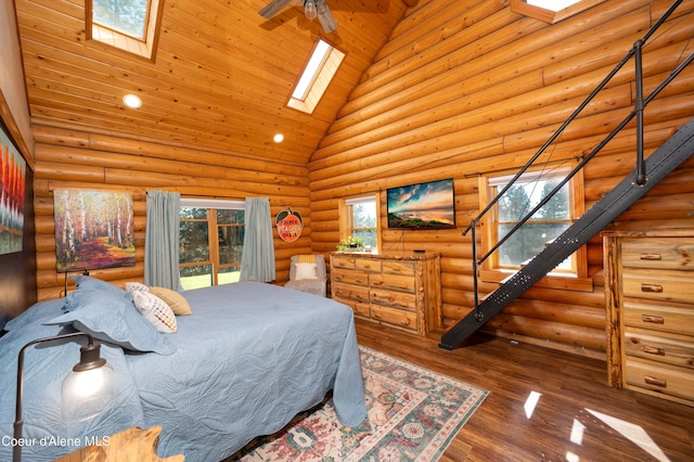bedroom featuring wood finished floors, high vaulted ceiling, a skylight, rustic walls, and recessed lighting