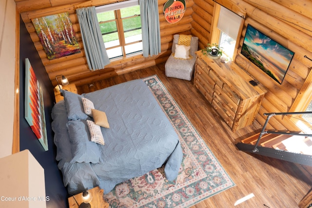 bedroom featuring rustic walls and wood finished floors