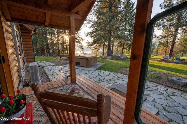 wooden deck featuring a hot tub and a patio area
