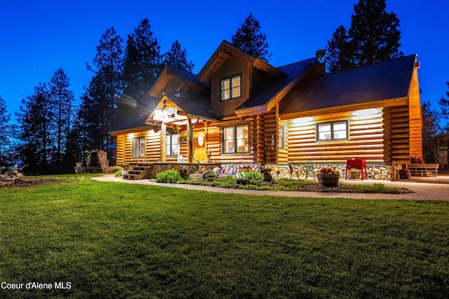 log cabin featuring a front yard, covered porch, stone siding, and log siding