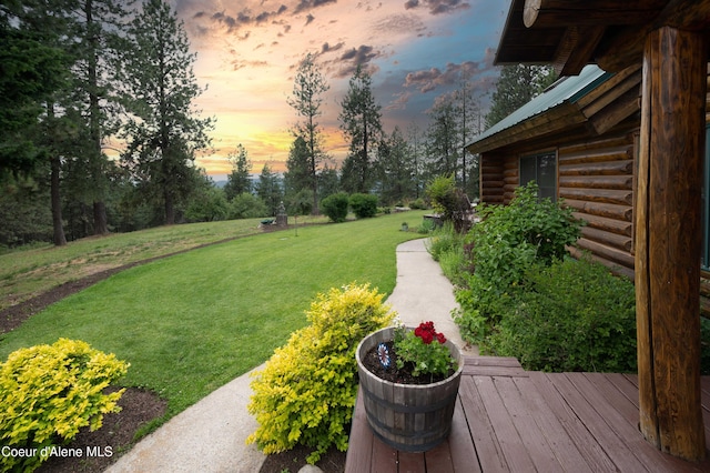 yard at dusk featuring a wooden deck