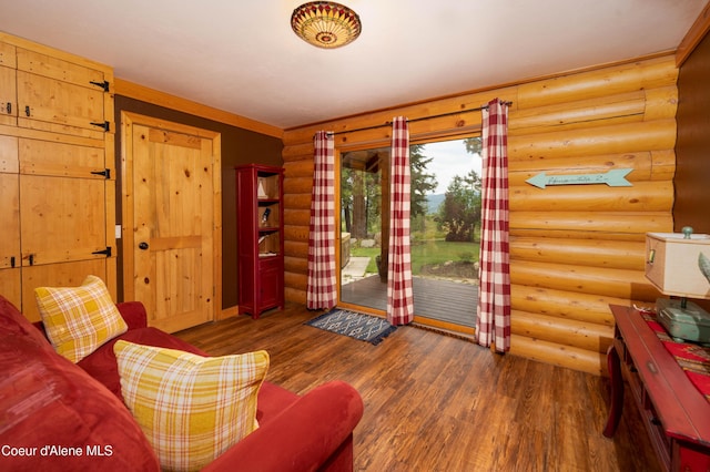 living room featuring log walls and wood finished floors