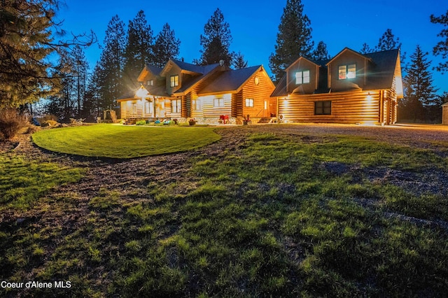 view of front of house featuring a front lawn and log exterior