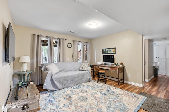 living area featuring baseboards, visible vents, and wood finished floors