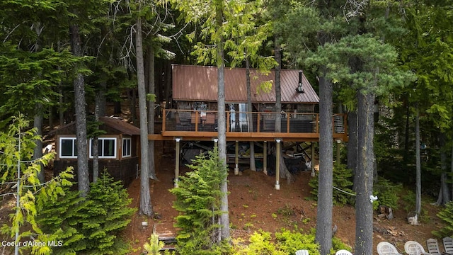 back of property featuring a deck and metal roof