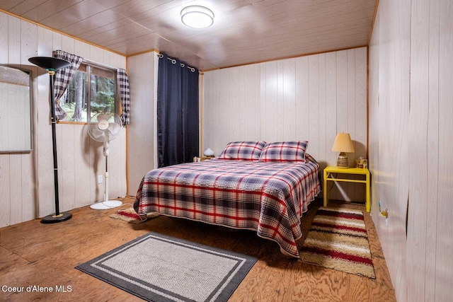 bedroom featuring wood ceiling, wooden walls, and wood finished floors