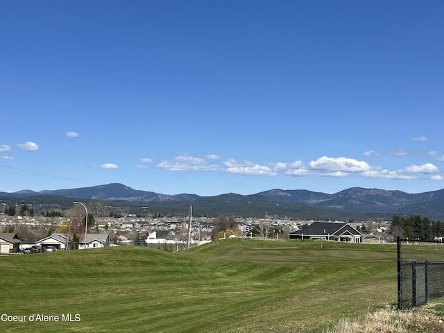 view of home's community featuring golf course view, a mountain view, a yard, and a residential view