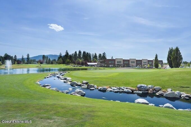 view of property's community featuring a lawn and a water and mountain view