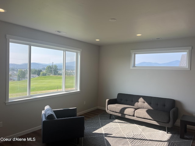 living room featuring visible vents, a mountain view, dark wood finished floors, and a wealth of natural light