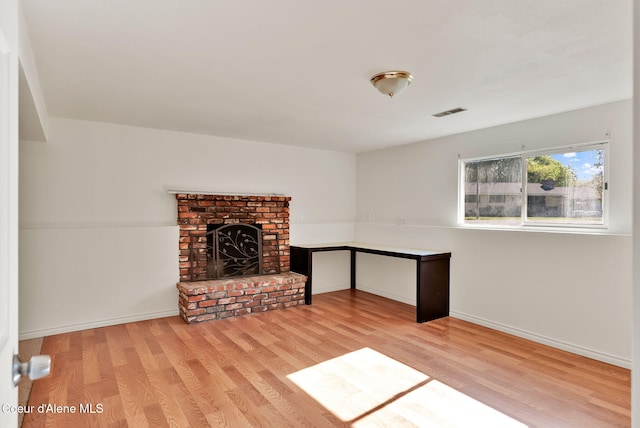 407 E Buttercup Ln, Coeur Dalene, ID 83815 - unfurnished living room with baseboards, a fireplace, wood finished floors, and visible vents