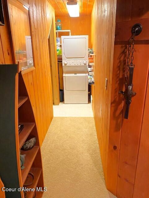 34128 N Scenic Bay D Dock Unit 21, Bayview, ID 83803 - corridor with wood walls and stacked washer and clothes dryer