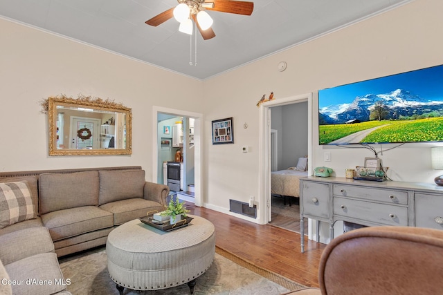 living area with wood finished floors, baseboards, and ceiling fan