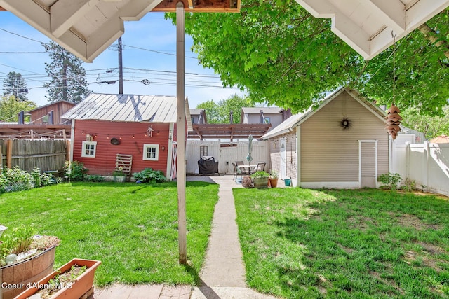 view of yard with a fenced backyard, a pergola, a patio area, and an outbuilding