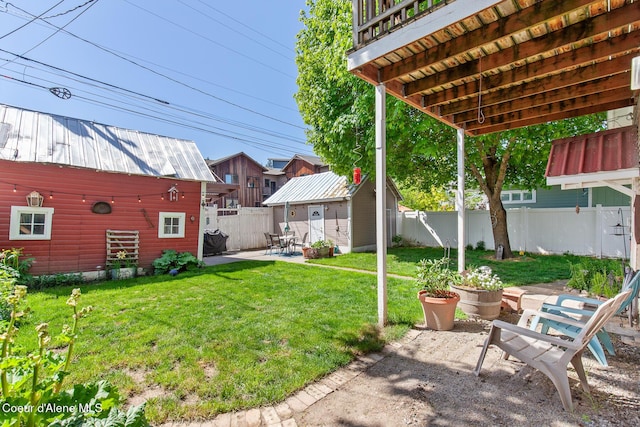 view of yard with an outbuilding, a patio, and a fenced backyard