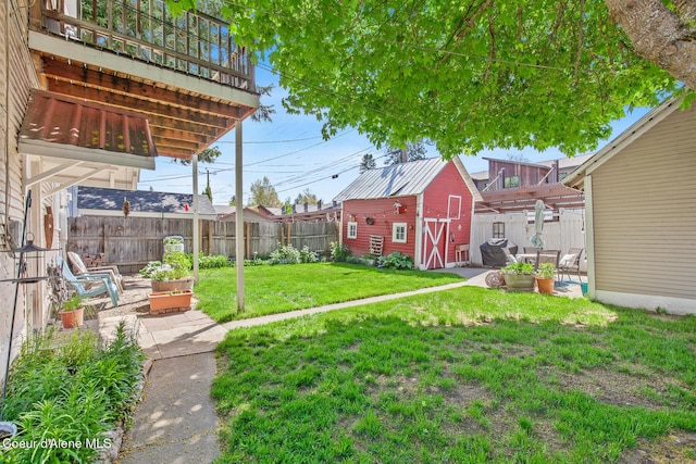 view of yard with a patio area, an outdoor structure, a shed, and a fenced backyard