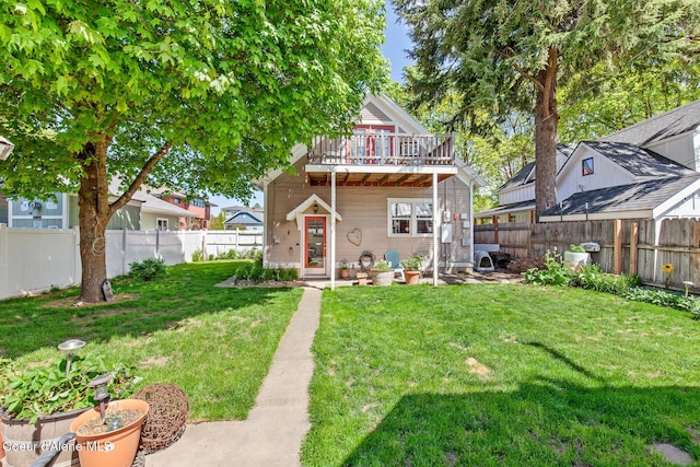 back of house with a fenced backyard and a lawn