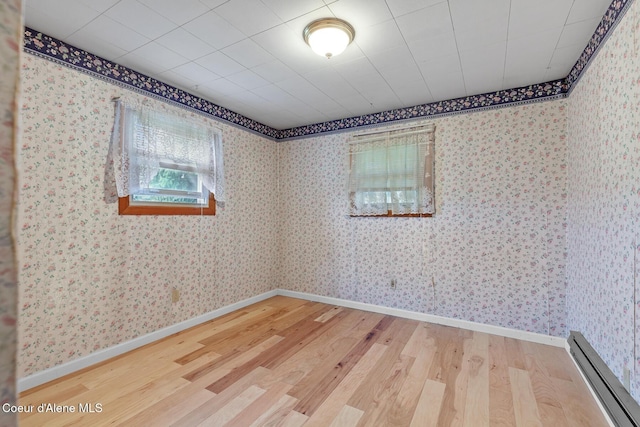 17871 N Ramsey Rd, Rathdrum, ID 83858 - unfurnished room with a baseboard heating unit, wood finished floors, and wallpapered walls