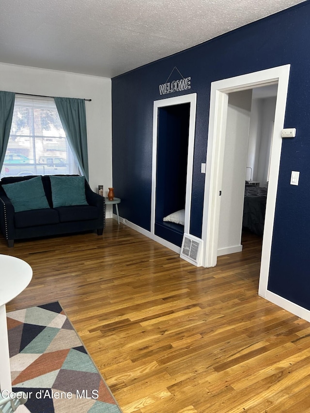 712 E Coeur D Alene Ave, Coeur Dalene, ID 83814 - living room with baseboards, visible vents, a textured ceiling, and wood finished floors