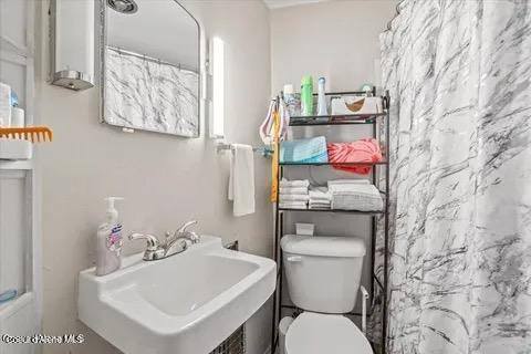 712 E Coeur D Alene Ave, Coeur Dalene, ID 83814 - bathroom featuring toilet, a sink, and curtained shower