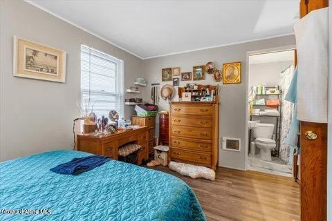 712 E Coeur D Alene Ave, Coeur Dalene, ID 83814 - bedroom featuring ornamental molding, ensuite bathroom, visible vents, and wood finished floors