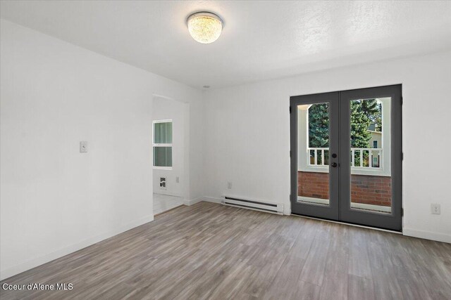 503 N 2nd St, Coeur Dalene, ID 83814 - unfurnished room with wood finished floors, baseboards, french doors, and a baseboard radiator