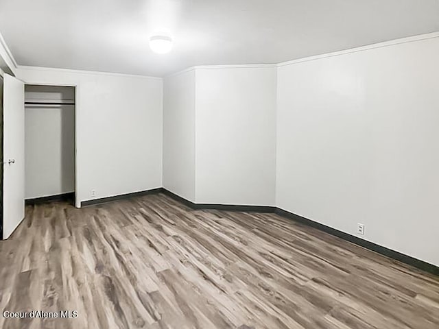 1422 E Young Ave, Coeur Dalene, ID 83814 - unfurnished bedroom with baseboards, a closet, crown molding, and wood finished floors