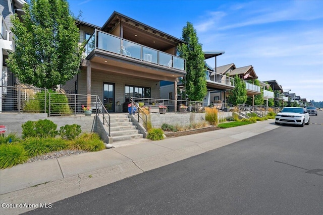 1755 W Bellerive Ln, Coeur Dalene, ID 83814 - view of front facade with fence, a balcony, and covered porch