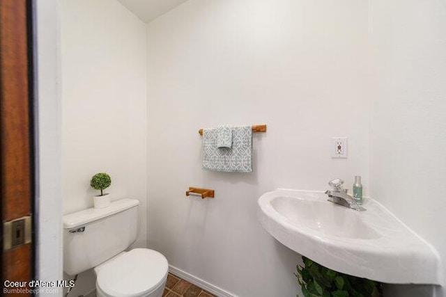 1547 E Stratford Dr, Hayden, ID 83835 - bathroom featuring a sink, toilet, and baseboards