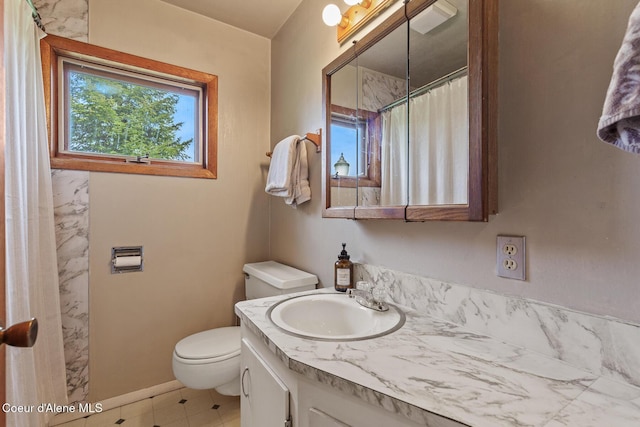 bathroom with toilet, baseboards, vanity, and a shower with curtain
