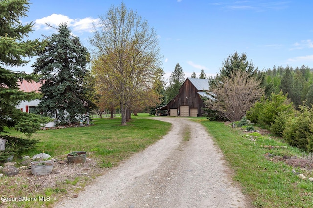 view of street featuring driveway and a barn