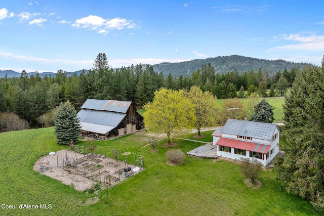 drone / aerial view with a mountain view and a view of trees