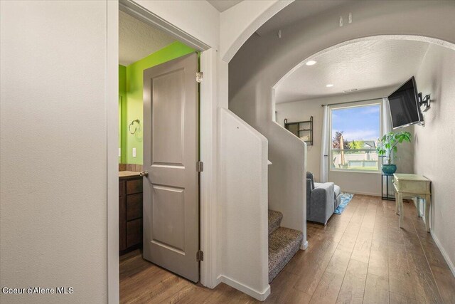 2097 W Calawah Ave, Post Falls, ID 83854 - corridor with wood finished floors, baseboards, stairs, and arched walkways