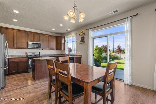 2097 W Calawah Ave, Post Falls, ID 83854 - dining space featuring a chandelier, recessed lighting, light wood-style flooring, baseboards, and a textured ceiling