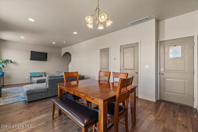 2097 W Calawah Ave, Post Falls, ID 83854 - dining area featuring a chandelier, arched walkways, dark wood-style floors, recessed lighting, and baseboards