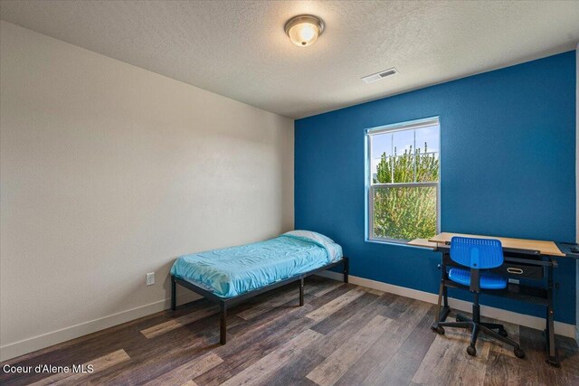 2097 W Calawah Ave, Post Falls, ID 83854 - bedroom featuring wood finished floors, baseboards, and a textured ceiling
