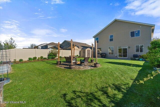 2097 W Calawah Ave, Post Falls, ID 83854 - rear view of property with a storage unit, an outdoor structure, and a patio