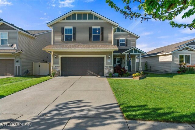 2097 W Calawah Ave, Post Falls, ID 83854 - craftsman-style house with an attached garage, driveway, a gate, and stone siding