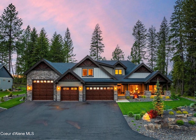 11671 N Spiraea Ln, Hayden, ID 83835 - craftsman house featuring stone siding, covered porch, driveway, and a yard
