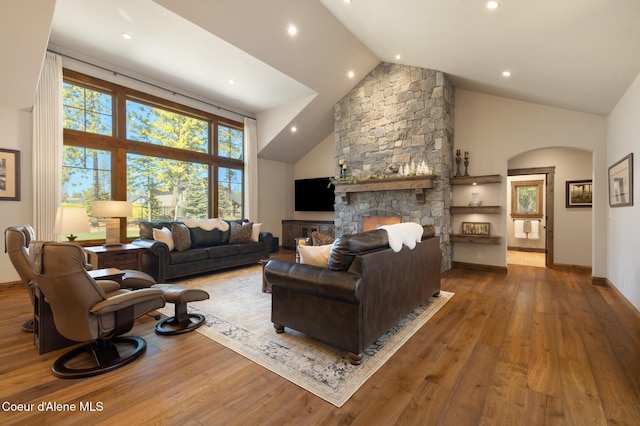 11671 N Spiraea Ln, Hayden, ID 83835 - living room with high vaulted ceiling, arched walkways, wood finished floors, a stone fireplace, and recessed lighting