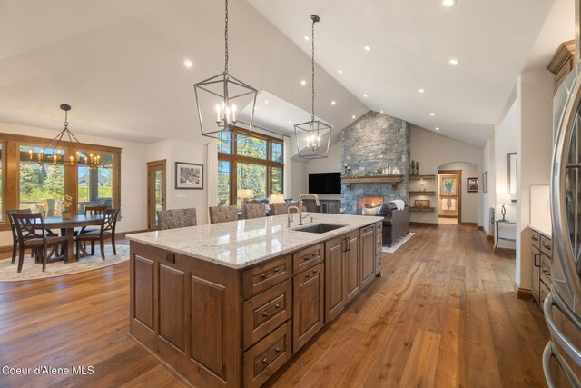11671 N Spiraea Ln, Hayden, ID 83835 - kitchen featuring a sink, a chandelier, a fireplace, hardwood / wood-style floors, and a center island with sink