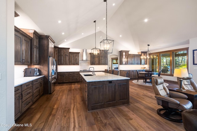 11671 N Spiraea Ln, Hayden, ID 83835 - kitchen featuring a chandelier, wall chimney exhaust hood, dark brown cabinetry, stainless steel refrigerator, and dark wood finished floors