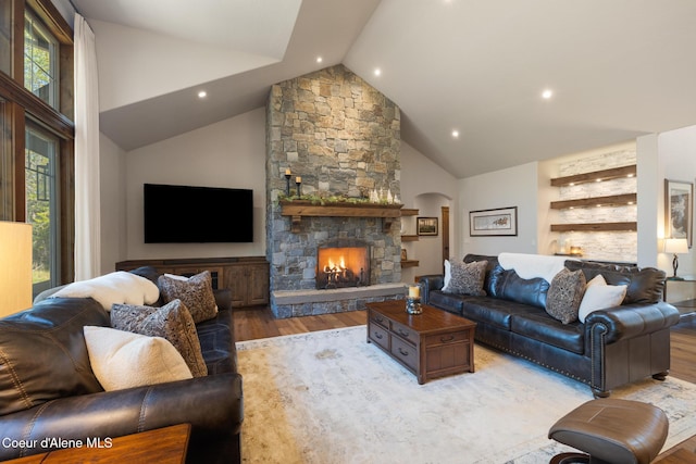 11671 N Spiraea Ln, Hayden, ID 83835 - living area with wood finished floors, healthy amount of natural light, arched walkways, high vaulted ceiling, and a stone fireplace