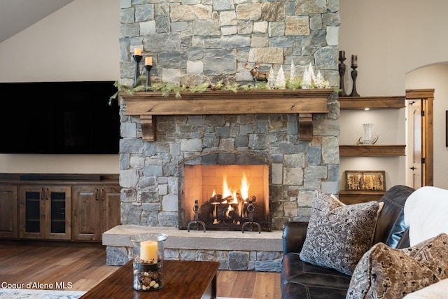11671 N Spiraea Ln, Hayden, ID 83835 - living area featuring arched walkways, wood finished floors, a stone fireplace, and lofted ceiling