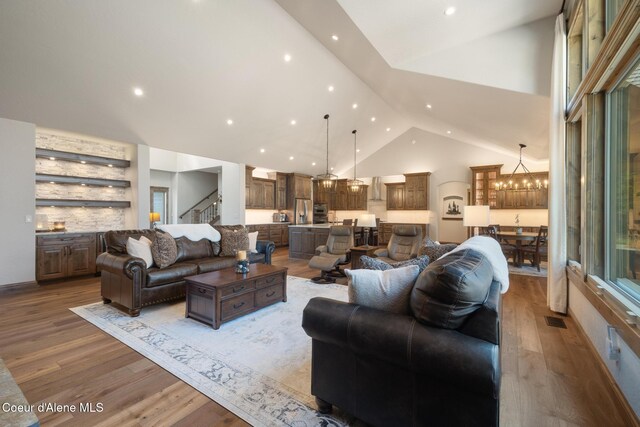 11671 N Spiraea Ln, Hayden, ID 83835 - living room with a chandelier, high vaulted ceiling, stairs, wood finished floors, and recessed lighting