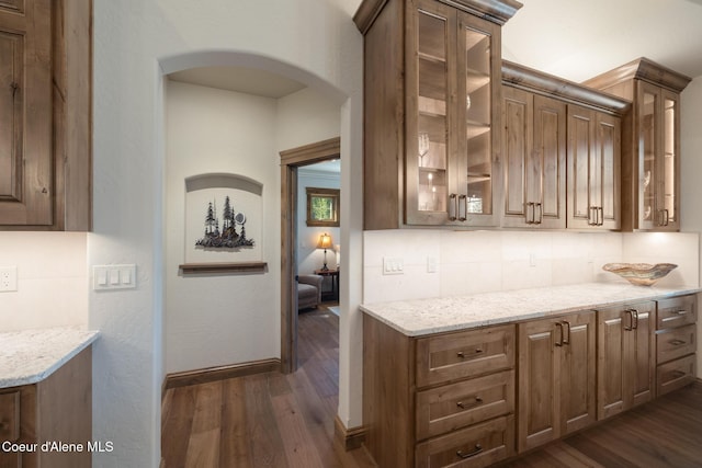 11671 N Spiraea Ln, Hayden, ID 83835 - bar area with dark wood-type flooring, arched walkways, backsplash, and baseboards