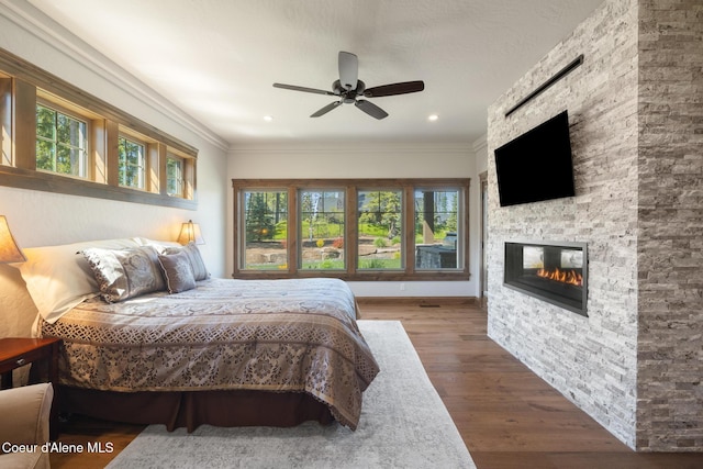 11671 N Spiraea Ln, Hayden, ID 83835 - bedroom featuring wood finished floors, multiple windows, a fireplace, crown molding, and ceiling fan